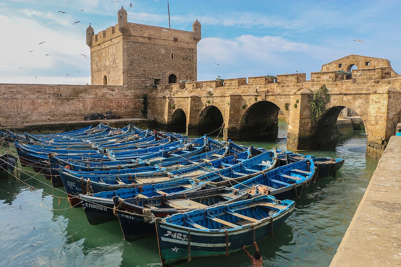 Puerto histórico de Essaouira con barcas de pesca azules y murallas del siglo XVIII, ciudad patrimonio UNESCO en la costa atlántica de Marruecos